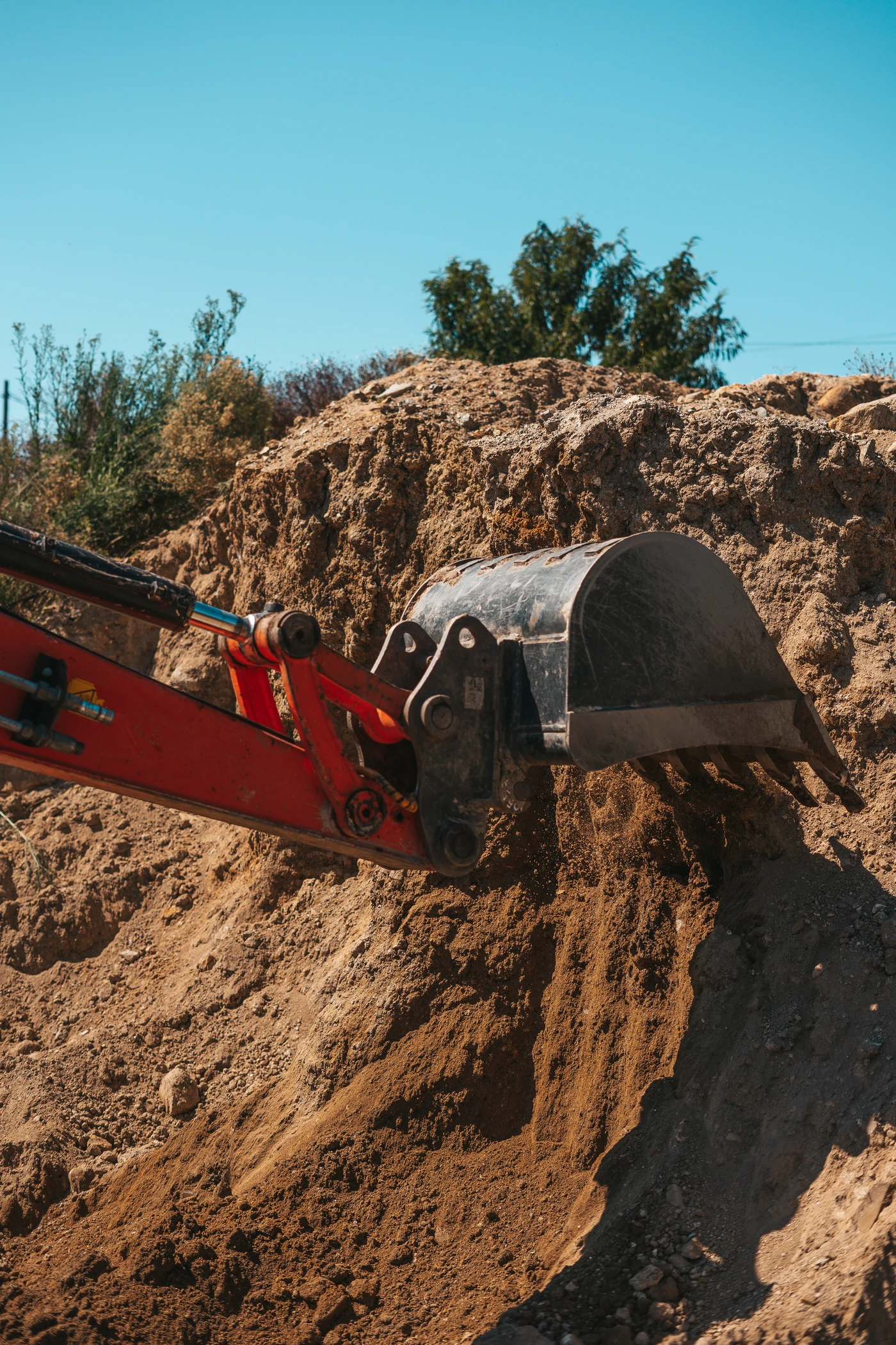 Excavadora removiendo ladera de tierra durante tareas de excavación experta en Valencia.